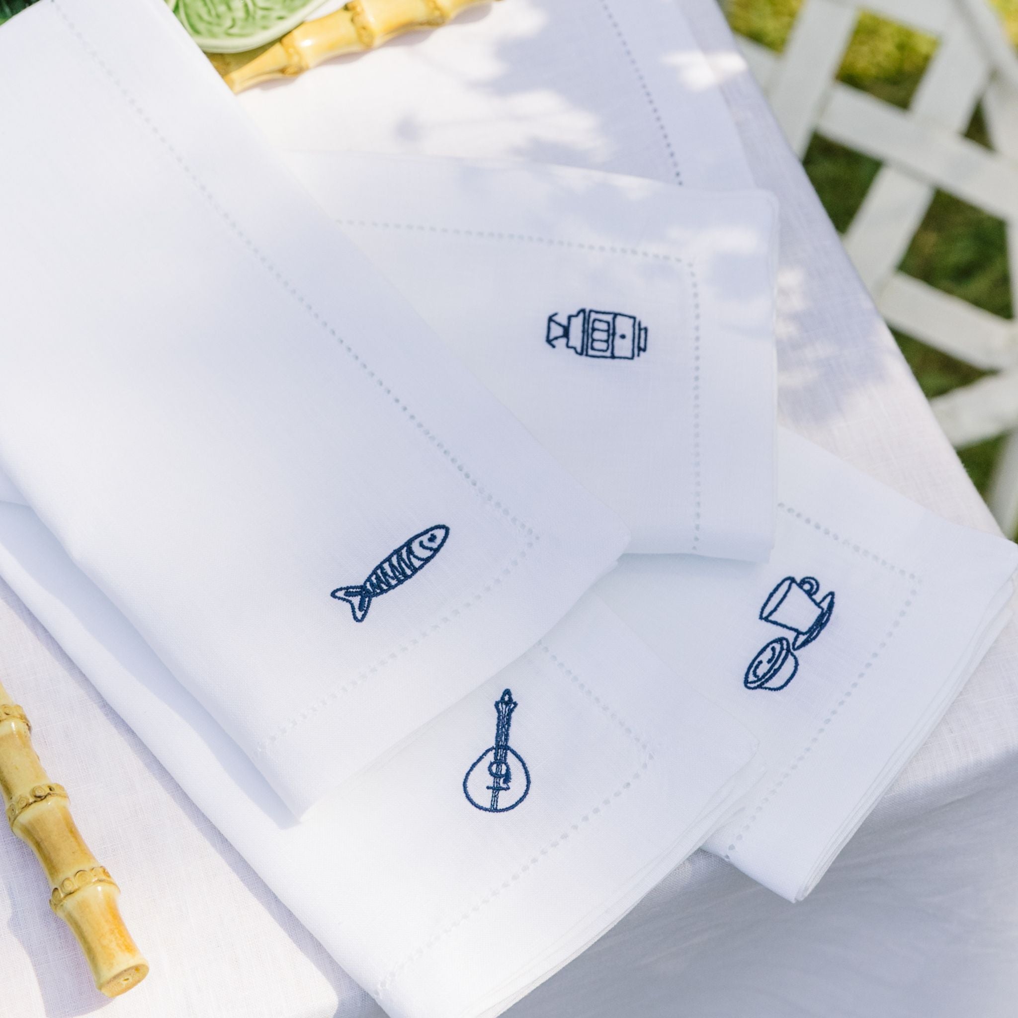 White napkins with blue embroidered designs on a white background